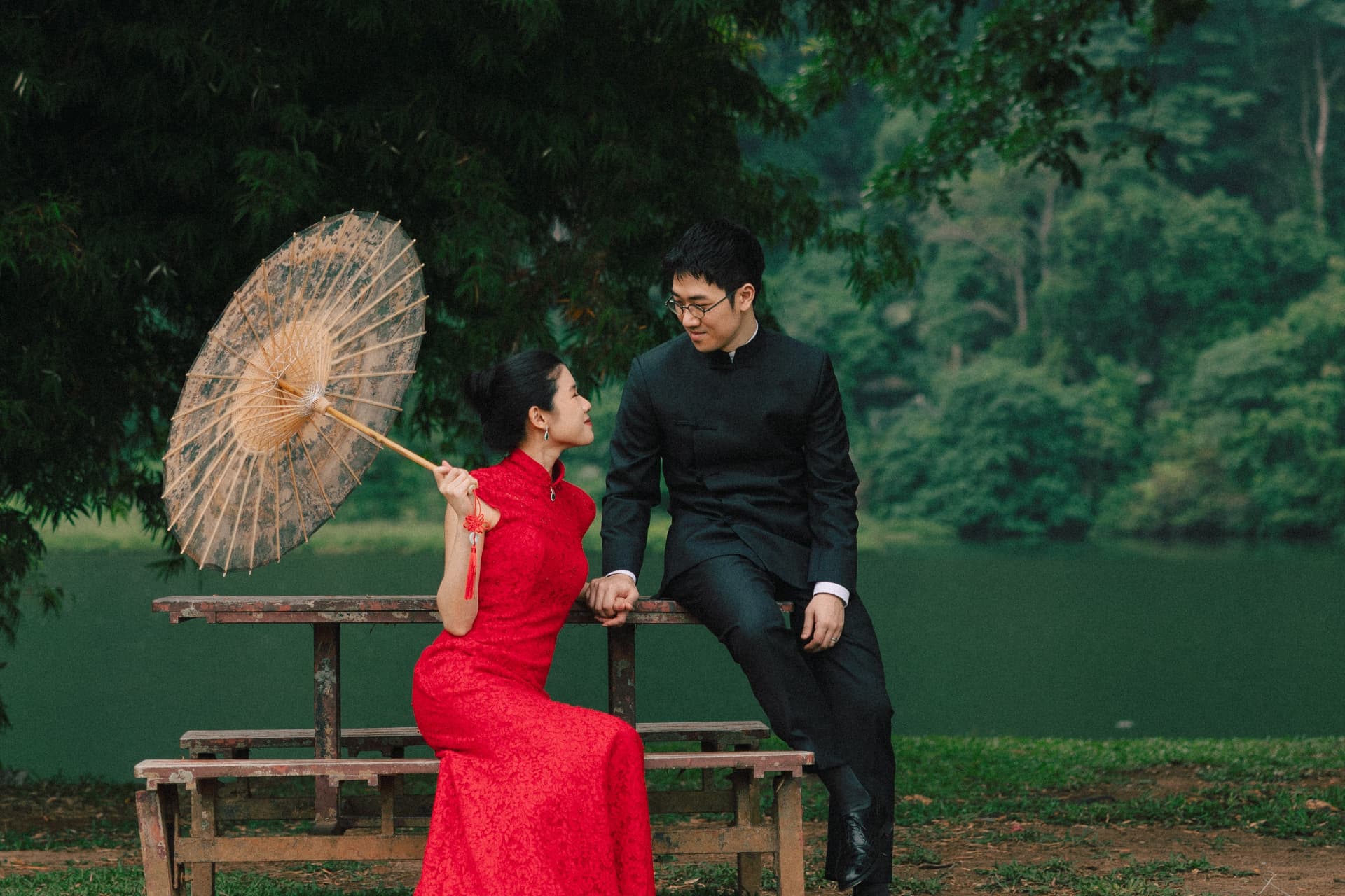 Wui Yan and Li Yen seated on a bench with a paper parasol